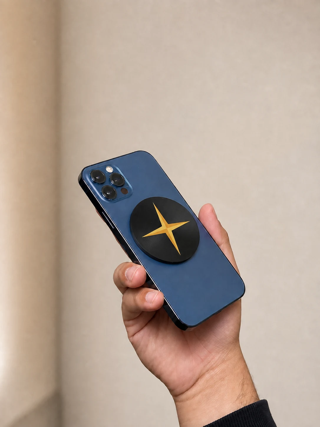 Black Forje Link with the gold Forje star attached to a blue iPhone